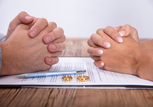 Closed hands of a couple over paperwork provided by a Divorce Attorney in Peoria IL