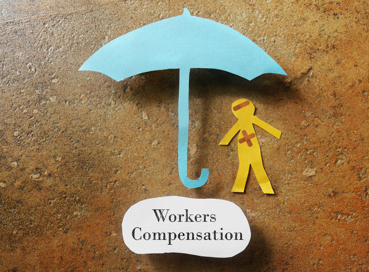 A paper doll being protected by a paper umbrella, representing workers compensation law in Central Illinois