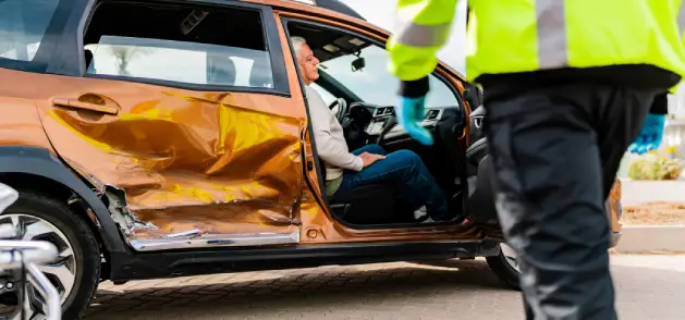 A man sits in a car after an accident as he waits for more information on how to handle a personal injury.