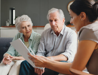 A senior couple reviews their wills and trusts with their advisor